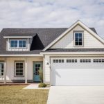 A white house with blue door and garage.